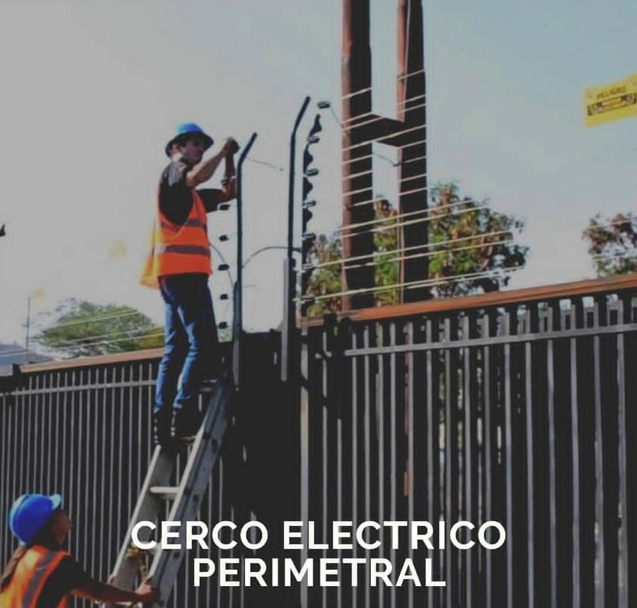 Técnicos de HSS instalando un cerco eléctrico sobre una reja perimetral