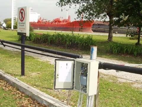 Controlador junto a muelle con buque al fondo
